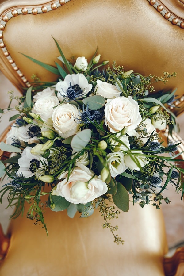 Beautiful wedding bouquet of flowers. White roses on a cold chair
