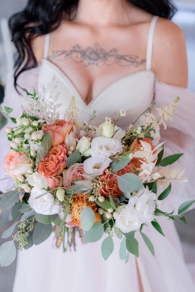wedding-bouquet-made-eustoma-eucalyptus-bridal-dress-with-open-decollete-tattoo-breasts